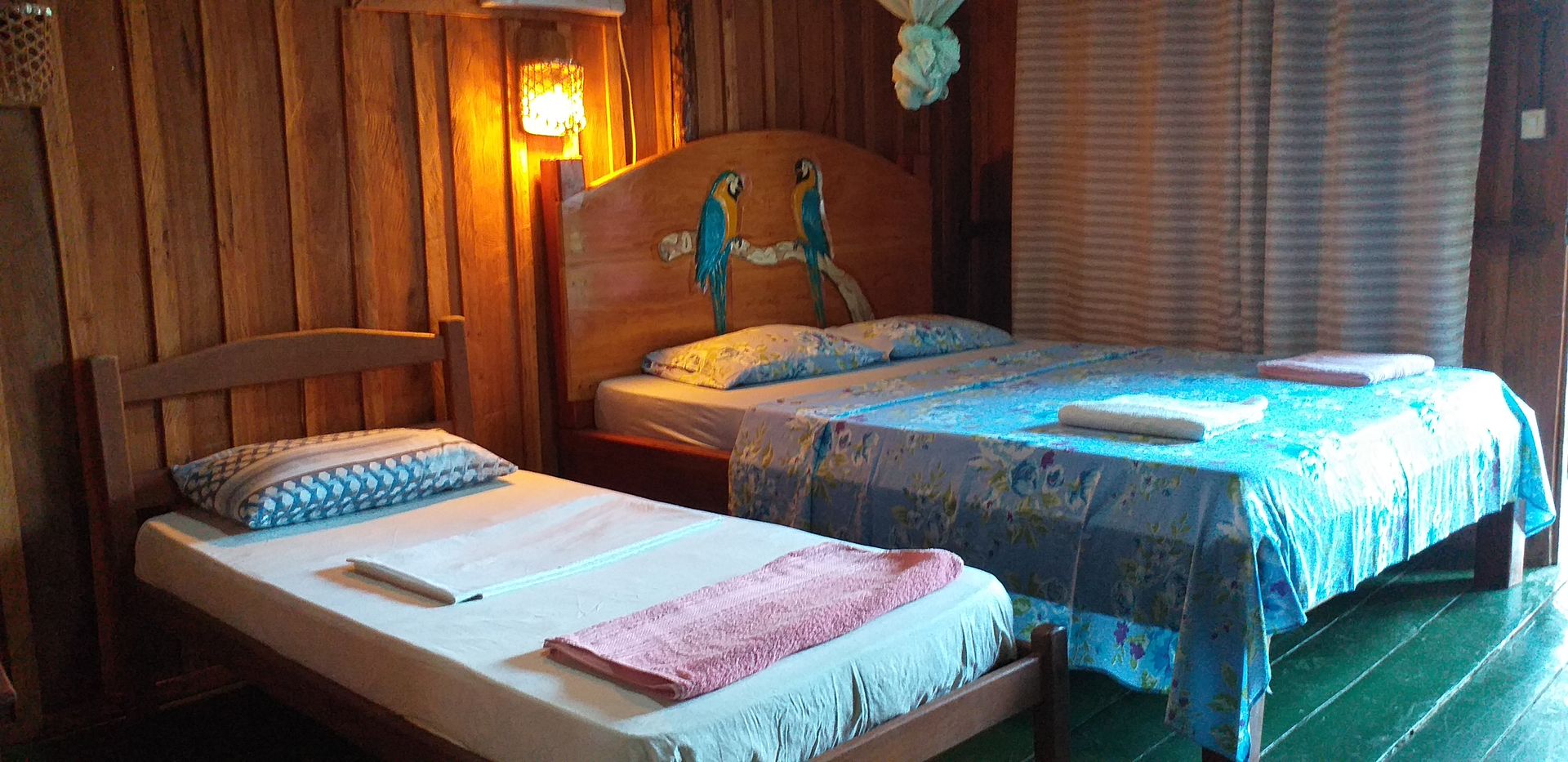 Lodge bedroom with macaw carved headboard and colourful handmade decor