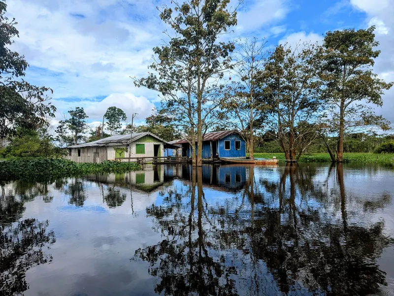 Riverside Amazon community reflected in floodwaters on the Jungle Retreat 4-day tour from Manaus