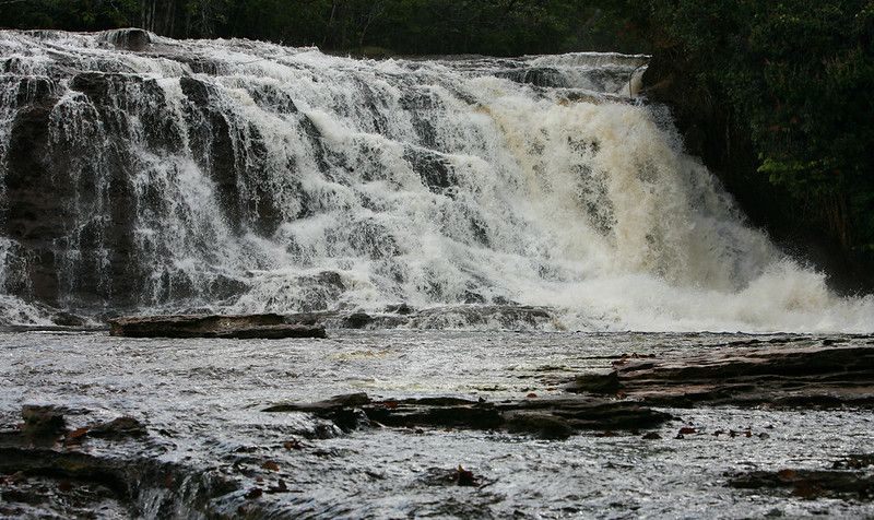 Cachoeira do Mutum — wide cascade over red sandstone into a natural pool, Presidente Figueiredo, Amazon, Brazil